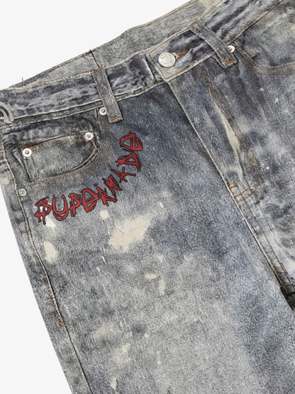 Distressed heavy-duty painted straight-leg jeans, adorned with red graffiti prints and paint-splatter wash effects 