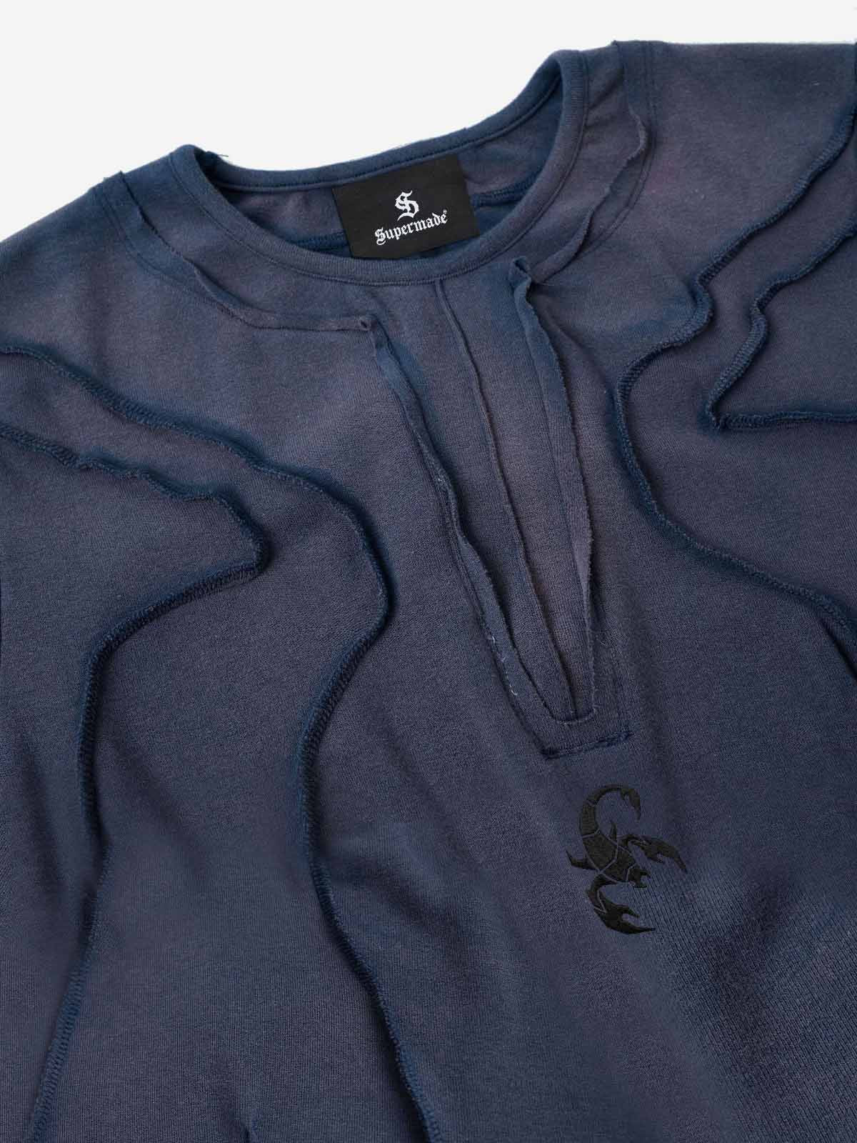 Camiseta con bordado de escorpión y costuras expuestas