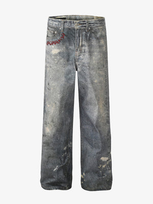 Distressed heavy-duty painted straight-leg jeans, adorned with red graffiti prints and paint-splatter wash effects 