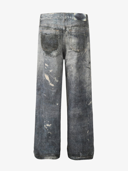 Distressed heavy-duty painted straight-leg jeans, adorned with red graffiti prints and paint-splatter wash effects 