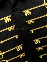 Camisa negra de algodón con botones y motivo de llave bordado en dorado.